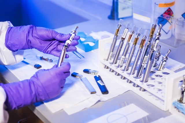 Mains gantées manipulant des tubes au cours d’un essai en milieu contrôlé